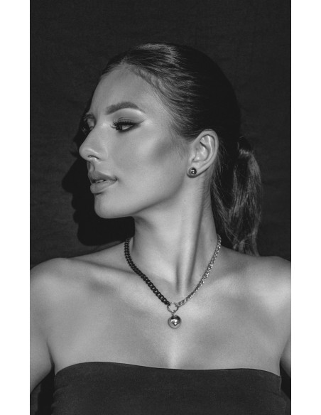 Krótki, regulowany naszyjnik ze stali szlachetnej z kulą o srebrnym połysku.