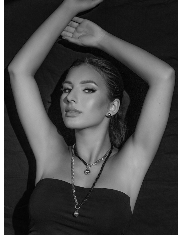 Krótki, regulowany naszyjnik ze stali szlachetnej z kulą o srebrnym połysku.