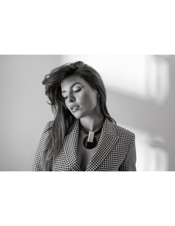 Naszyjnik ze skóry naturalnej z pozłacaną ozdobną zawieszką i czarnymi stalowymi elementami.