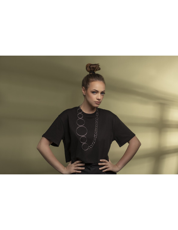 Długi srebrny naszyjnik ze stali szlachetnej z połączonych kół o różnej średnicy.