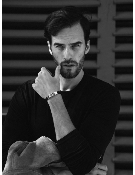 Męska czarna skórzana bransoletka ze złotym stalowym elementem i zegarkowym zapięciem.